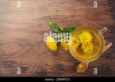 Tazza ph sano tè dente di leone su vintage sfondo di legno. Erbe fresche Foto Stock