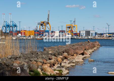 Vecchio frangiflutti in pietra con il porto di Vuosaari sullo sfondo a Helsinki, Finlandia Foto Stock