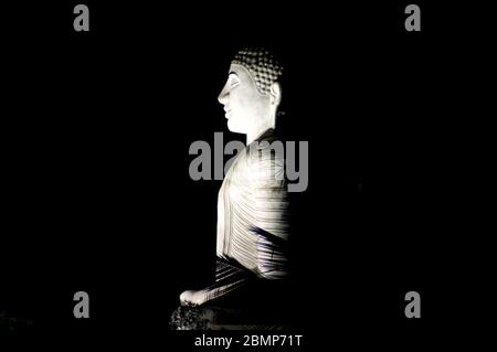 Una statua illuminata di buddha di signore a Kandy, Sri Lanka. Questa imponente statua in pietra è una delle principali attrazioni di Kandy. Foto Stock