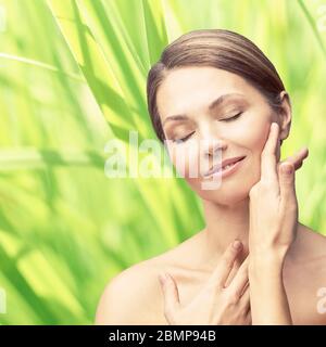 Ritratto di bellezza naturale con le mani. Cosmetologia faccia donna matura. Foto Stock