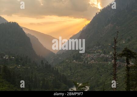 Ultimo sole raggi in serata passando attraverso la valle Parvati in Himalaya vicino Manali, Himachal Pradesh; India Foto Stock