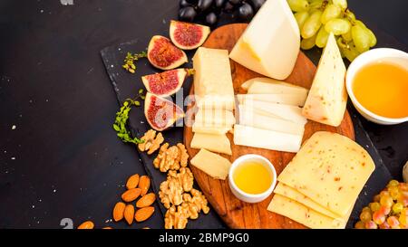 Il piatto di formaggi serviti con uve, marmellata, fichi, cracker e dadi Foto Stock