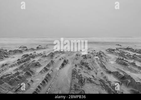 Rocce frastagliate che conducono al mare nella Cornovaglia settentrionale Foto Stock