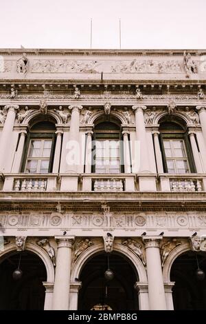 Finestre e colonne d'epoca ornate, in stile veneziano, su un frammento del lussuoso edificio di Venezia. Tradizionale stile gotico antico. Tre Foto Stock