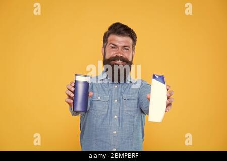 Essenziale per una buona igiene. Bottigliette per gel e shampoo hippster. Uomo con bearded con prodotti di igiene. Cosmetici e articoli da toeletta. Abitudini di igiene personale. Igiene e salute. Foto Stock