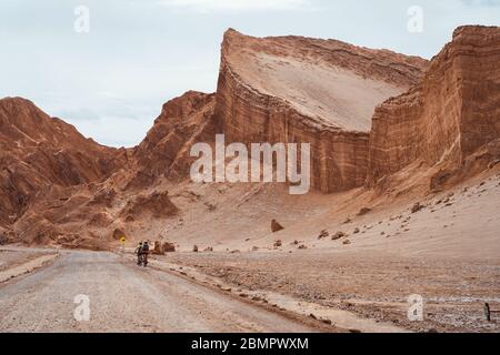 Ciclisti nella Valle della Luna (in spagnolo: Valle de la Luna) nel deserto di Atacama, Cile, Sud America. Foto Stock