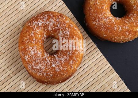 Ciambella polacca, ciambelle dolci tradizionali su sfondo nero. Cibo delizioso ma non salutare sul vecchio tavolo di legno con spazio per le copie Foto Stock