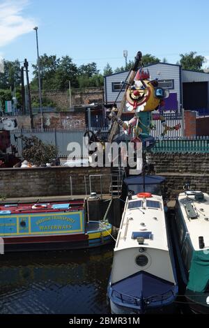 Scultura di clown fatta di rottami oltre ad un cantiere navale sulle rive del fiume Calder, di fronte all'ingresso della Galleria Hepworth. Foto Stock