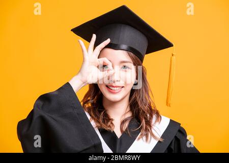 giovane donna felice in laurea si sposa con gesto di sguardo Foto Stock