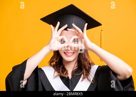 giovane donna felice in laurea si sposa con gesto di sguardo Foto Stock