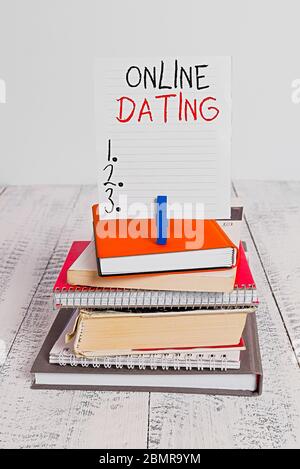 Testo di scrittura di parole Online Dating. Foto di affari che mostra Ricerca di corrispondenza relazioni eDating Video chatting pila di libri impilati notebook pin clo Foto Stock