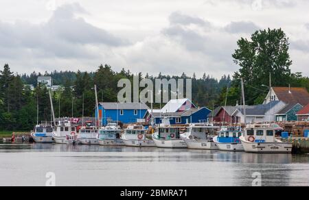 North rustico Harbour – un pittoresco villaggio di pescatori sull'Isola del Principe Edoardo, Canada. Barche ormeggiate al molo. Capanne di pescatori che costeggiano la riva. Foto Stock