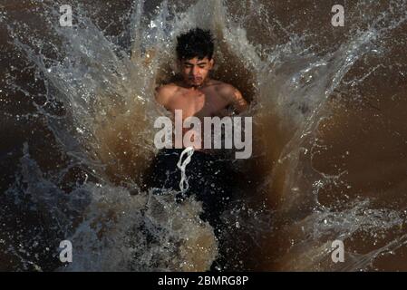 Lahore, Pakistan. 10 maggio 2020. Il giovane pakistano si gode il bagno nell'acqua del canale per battere il caldo e ottenere un certo sollievo dal tempo caldo a Ramazan-ul-Mubarak a Lahore. (Foto di Rana Sadid Hussain/Pacific Press) Credit: Pacific Press Agency/Alamy Live News Foto Stock