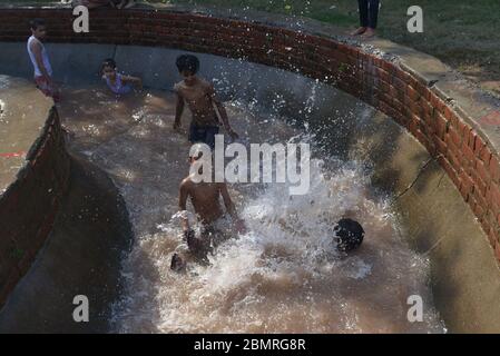 Lahore, Pakistan. 10 maggio 2020. Il giovane pakistano si gode il bagno nell'acqua del canale per battere il caldo e ottenere un certo sollievo dal tempo caldo a Ramazan-ul-Mubarak a Lahore. (Foto di Rana Sadid Hussain/Pacific Press) Credit: Pacific Press Agency/Alamy Live News Foto Stock