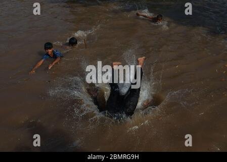 Lahore, Pakistan. 10 maggio 2020. Il giovane pakistano si gode il bagno nell'acqua del canale per battere il caldo e ottenere un certo sollievo dal tempo caldo a Ramazan-ul-Mubarak a Lahore. (Foto di Rana Sadid Hussain/Pacific Press) Credit: Pacific Press Agency/Alamy Live News Foto Stock