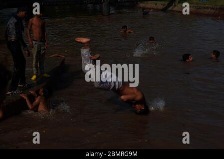 Lahore, Pakistan. 10 maggio 2020. Il giovane pakistano si gode il bagno nell'acqua del canale per battere il caldo e ottenere un certo sollievo dal tempo caldo a Ramazan-ul-Mubarak a Lahore. (Foto di Rana Sadid Hussain/Pacific Press) Credit: Pacific Press Agency/Alamy Live News Foto Stock