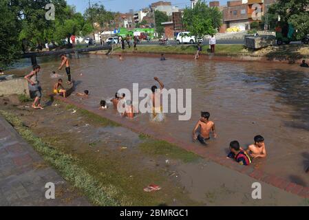 Lahore, Pakistan. 10 maggio 2020. Il giovane pakistano si gode il bagno nell'acqua del canale per battere il caldo e ottenere un certo sollievo dal tempo caldo a Ramazan-ul-Mubarak a Lahore. (Foto di Rana Sadid Hussain/Pacific Press) Credit: Pacific Press Agency/Alamy Live News Foto Stock