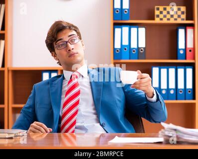 Il giovane uomo politico bello seduto in ufficio Foto Stock