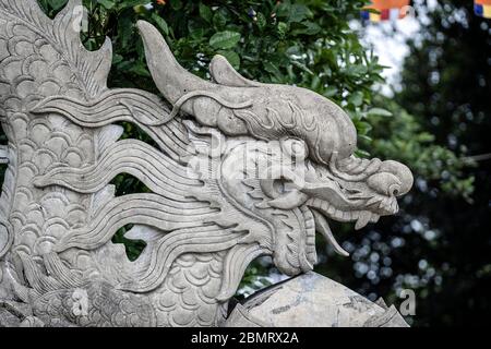 Scultura drago in pietra all'ingresso di un tempio buddista nella città di Danang, Vietnam. Primo piano Foto Stock