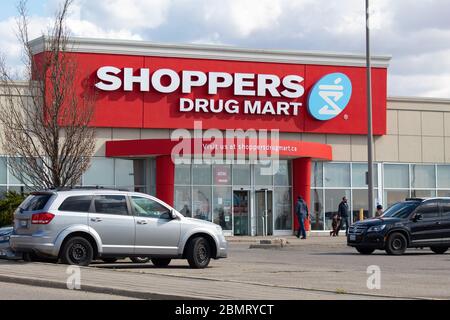 Ingresso frontale al negozio Drug Mart Shoppers come persone, ingresso e uscita in una giornata di sole. Foto Stock