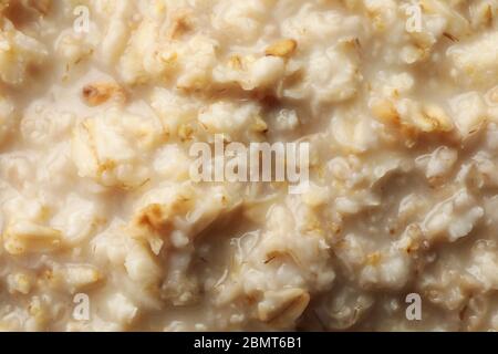 Porridge di farina d'avena su tutto lo sfondo, primo piano Foto Stock
