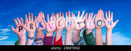 Bambini mani costruire Parola Praevention significa prevenzione, cielo blu Foto Stock