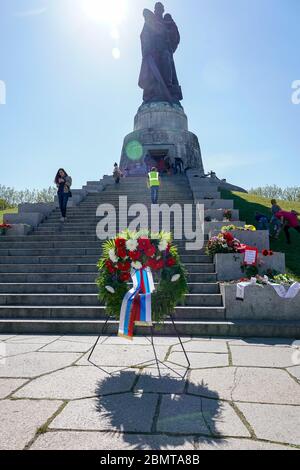 09.05.2020, Berlino, corona dell'Ambasciata della Federazione Russa. All'OSS War Memorial nel Treptower Park (Treptower War Memorial), un monumento commemorativo e allo stesso tempo un cimitero militare, numerosi russi e tedeschi-russi commemorano il 75° giorno di vittoria alla fine della seconda guerra mondiale con molte bandiere colorate. Il memoriale fu eretto nel 1949 su istruzioni dell'amministrazione militare sovietica in Germania per onorare i soldati dell'esercito rosso che morì nella seconda guerra mondiale Qui sono sepolti oltre 7000 soldati morti nelle Schride intorno a Berlino. Il supporto del contatto corona Foto Stock