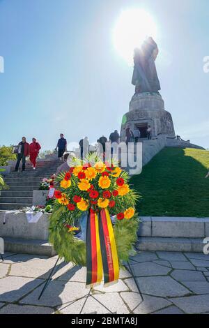 09.05.2020, Berlino, corona del governo federale tedesco. All'OSS War Memorial nel Treptower Park (Treptower War Memorial), un monumento commemorativo e allo stesso tempo un cimitero militare, numerosi russi e tedeschi-russi commemorano il 75° giorno di vittoria alla fine della seconda guerra mondiale con molte bandiere colorate. Il memoriale fu eretto nel 1949 su istruzioni dell'amministrazione militare sovietica in Germania per onorare i soldati dell'esercito rosso che morì nella seconda guerra mondiale Qui sono sepolti oltre 7000 soldati morti nelle Schride intorno a Berlino. Le restrizioni di contatto della corona Foto Stock