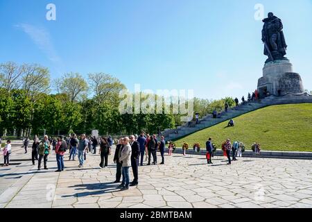 09.05.2020, Berlino, al Memoriale della Guerra Sovietica nel Parco Treptower (Treptower War Memorial), un memoriale e allo stesso tempo un cimitero militare, numerosi russi e tedeschi-russi con molte bandiere colorate commemorano il 75° giorno di vittoria alla fine della seconda Guerra Mondiale. Il memoriale fu eretto nel 1949 su istruzioni dell'amministrazione militare sovietica in Germania per onorare i soldati dell'esercito rosso che morì nella seconda guerra mondiale Qui sono sepolti oltre 7000 soldati morti nelle Schride intorno a Berlino. Le restrizioni di contatto della corona rendono l'evento molto più piccolo del solito. Foto Stock