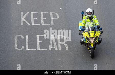 Un poliziotto in servizio su una moto nel centro di Londra, mentre il Regno Unito continua a bloccare per contribuire a frenare la diffusione del coronavirus. Foto Stock
