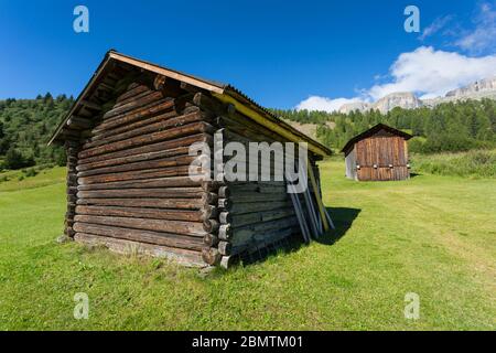 Granai e montagne in legno in alta Badia vicino Corvara, Dolomiti, Alto Adige, Italia, Europa Foto Stock
