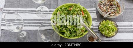 Un tavolo da picnic con una grande ciotola di insalata e piatti da giardino con ciottoli Foto Stock