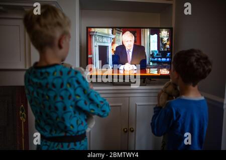 Orologi di famiglia il primo ministro Boris Johnson discorso la nazione britannica sulla televisione nazionale che stabilisce i passi di una 'Road map' fuori di Coronavirus blocco Foto Stock