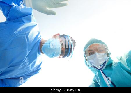Chirurghi che eseguono operazioni in sala operatoria, team medico sta dando pronto soccorso, medici in ospedale, concetto di coronavirus. Foto Stock
