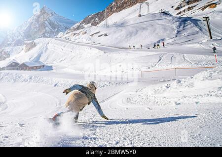 Snowboarder su un pendio nelle alpi Italiane Foto Stock