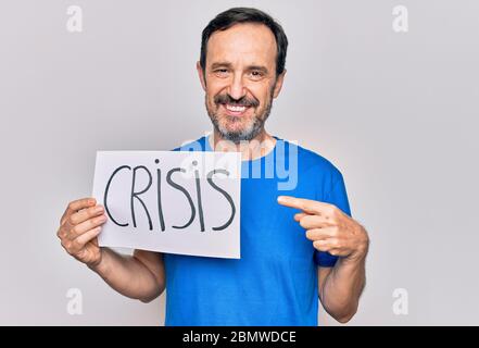 Uomo bello di mezza età con carta di crisi su sfondo bianco isolato sorridendo felice indicando con mano e dito Foto Stock