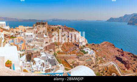 Il bellissimo villaggio di Oia sull'isola di Santorini e le rovine del castello bizantino costruite sul lato della scogliera della caldera. Foto Stock