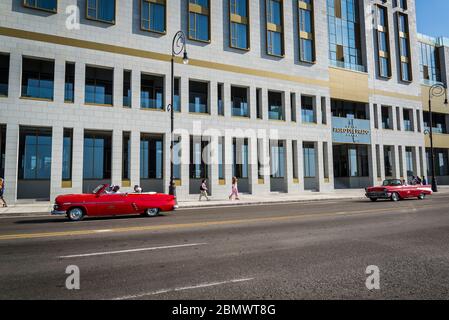 Auto classiche che passano dal Paseo del Prado Hotel, lungo il Malecon o Avenida de Maceo, un'ampia spianata e strada che si estende per 8 km lungo il coa Foto Stock