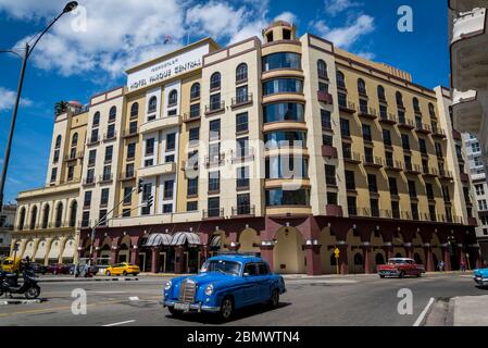 Auto classiche che passano dall'Hotel Parque Centra, IBEROSTAR Parque Central, hotel a 5 stelle nella Piazza Centrale, l'Avana, Cuba Foto Stock