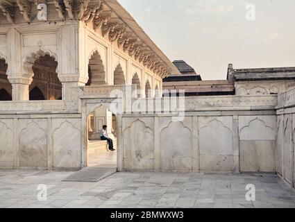 AGRA, Uttar Pradesh, India - 25 Febbraio 2015: il ritratto di una guardia di sicurezza seduto all'interno dell'entrata dell'antica Agra Fort costruito dal Mugha Foto Stock