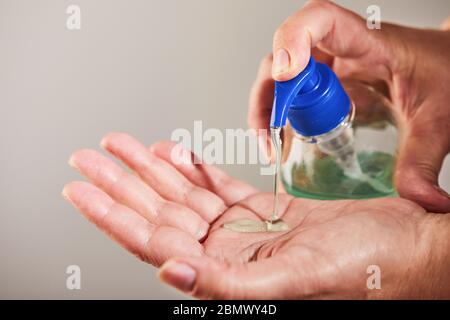 Pulizia delle mani con gel igienizzante per le mani con alcol flacone a pressione al 70% per i rubini delle mani. Protezione contro virus e batteri. Covid-19 OR Foto Stock