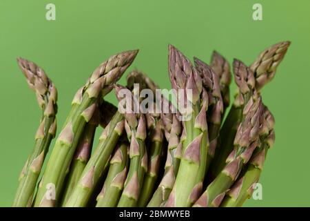 Asparagi verdi freschi su sfondo verde, vista ravvicinata Foto Stock
