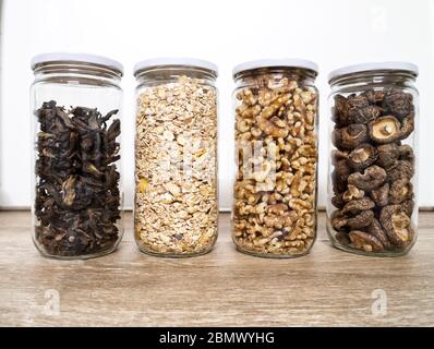 Stoccaggio di alimenti sfusi in vasetti di vetro: Funghi selvatici secchi, muesli e noci. Concetto di zero sprechi. Foto Stock