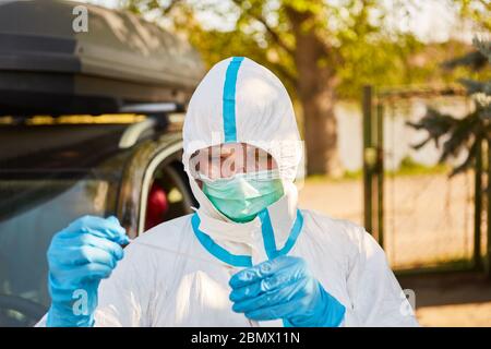 Medic esegue un test rapido del coronavirus come striscio di gola nella stazione di test drive-in Foto Stock