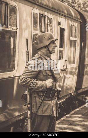 Vista vintage seppia del soldato nazista in servizio presso la stazione ferroviaria Heritage, Severn Valley Railway, evento estivo degli anni '40, Regno Unito. Foto Stock
