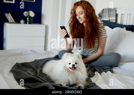 Cane e la sua proprietaria sul letto Foto Stock