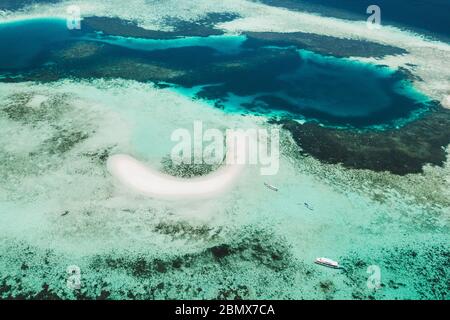 Vista aerea dell'isola di Taka Makassar nel parco nazionale di Komodo, Indonesia. Paradiso vuoto piccola isola di sabbia bianca sulla barriera corallina. Foto Stock