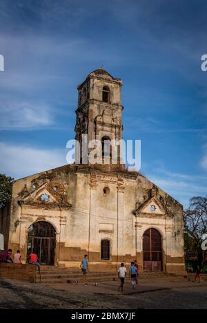 I bambini che giocano a calcio di fronte al derelict e hanno chiuso la Chiesa di Saint Ana, Trinidad, Cuba Foto Stock