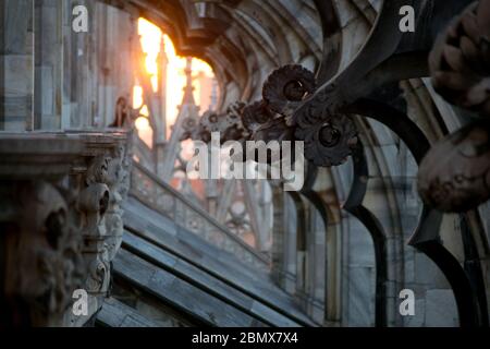 Milano, 22 marzo 2019: Sul tetto della chiesa del Duomo il dettaglio dei contrafforti decorati in pietra all'ora del tramonto Foto Stock