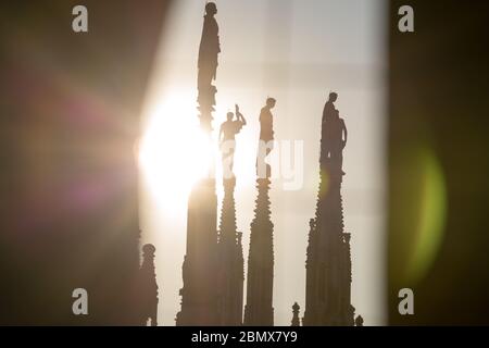 Milano, 22 marzo 2019: Sul tetto della chiesa del Duomo silhouette retroilluminate di alcune delle numerose statue sopra le spier Foto Stock